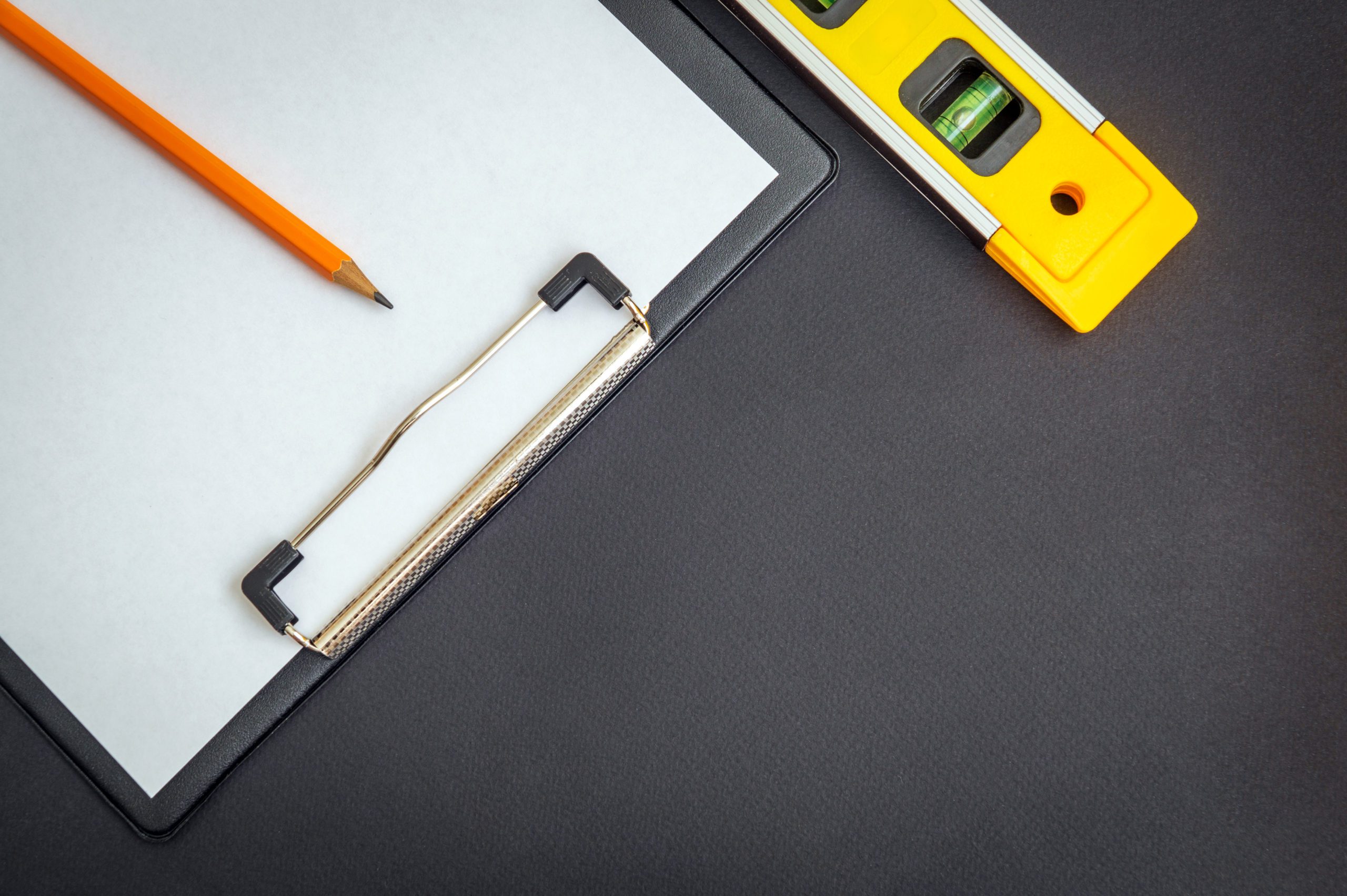 Tablet with blank sheet of paper for drawing up a work plan and Building level